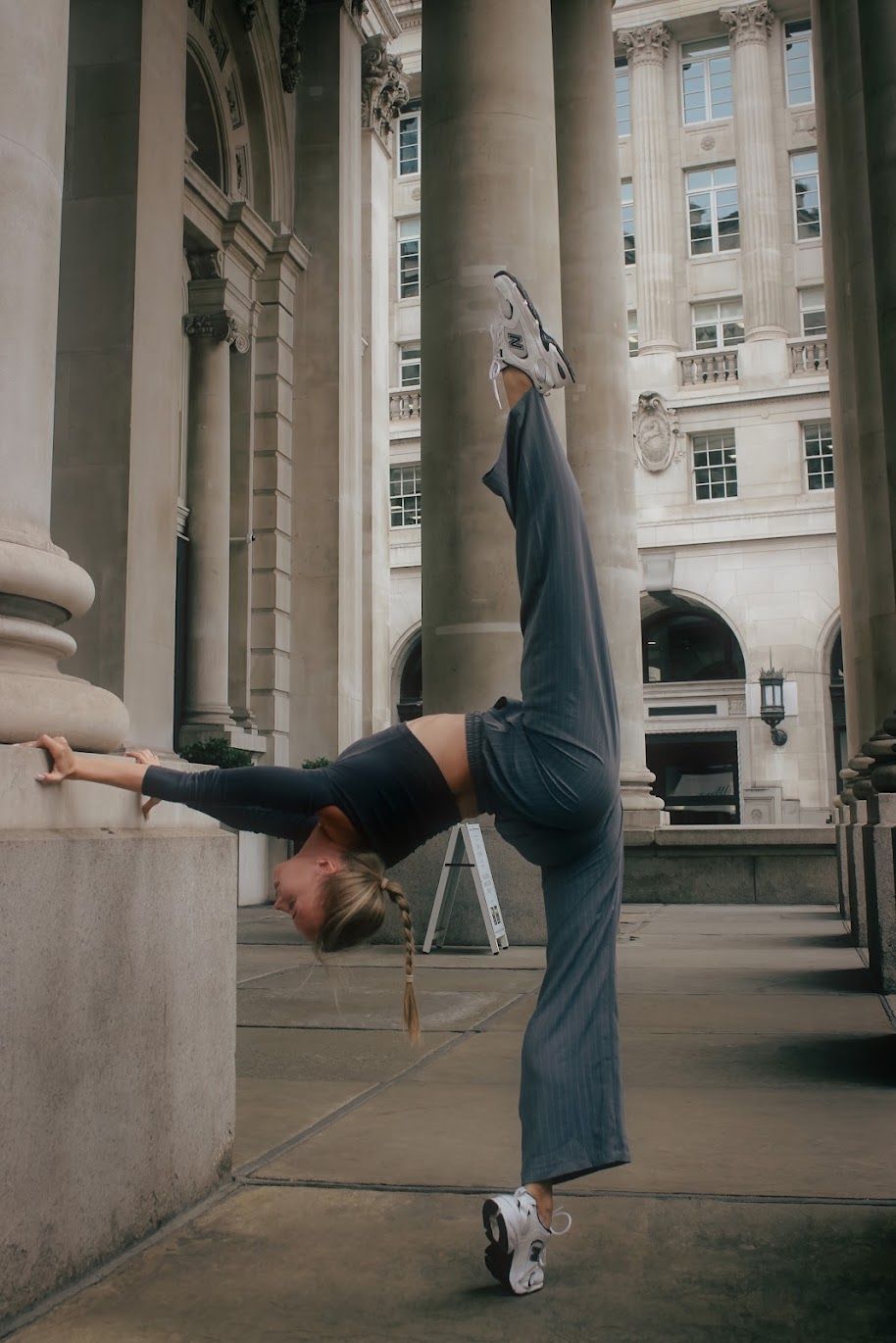 Viktoriia in a standing backbend balance outside the Bank of England
